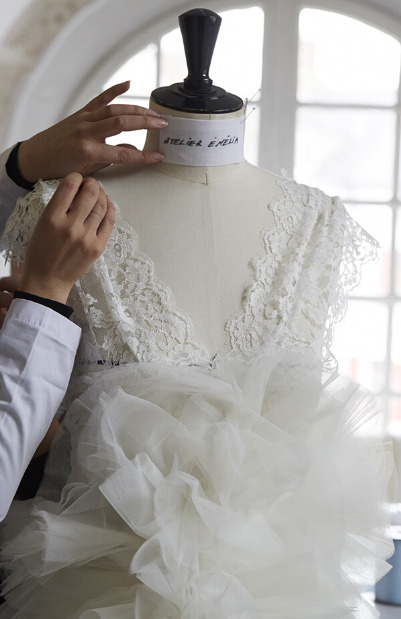 Une couturière travaille sur la confection d'une robe de mariée
